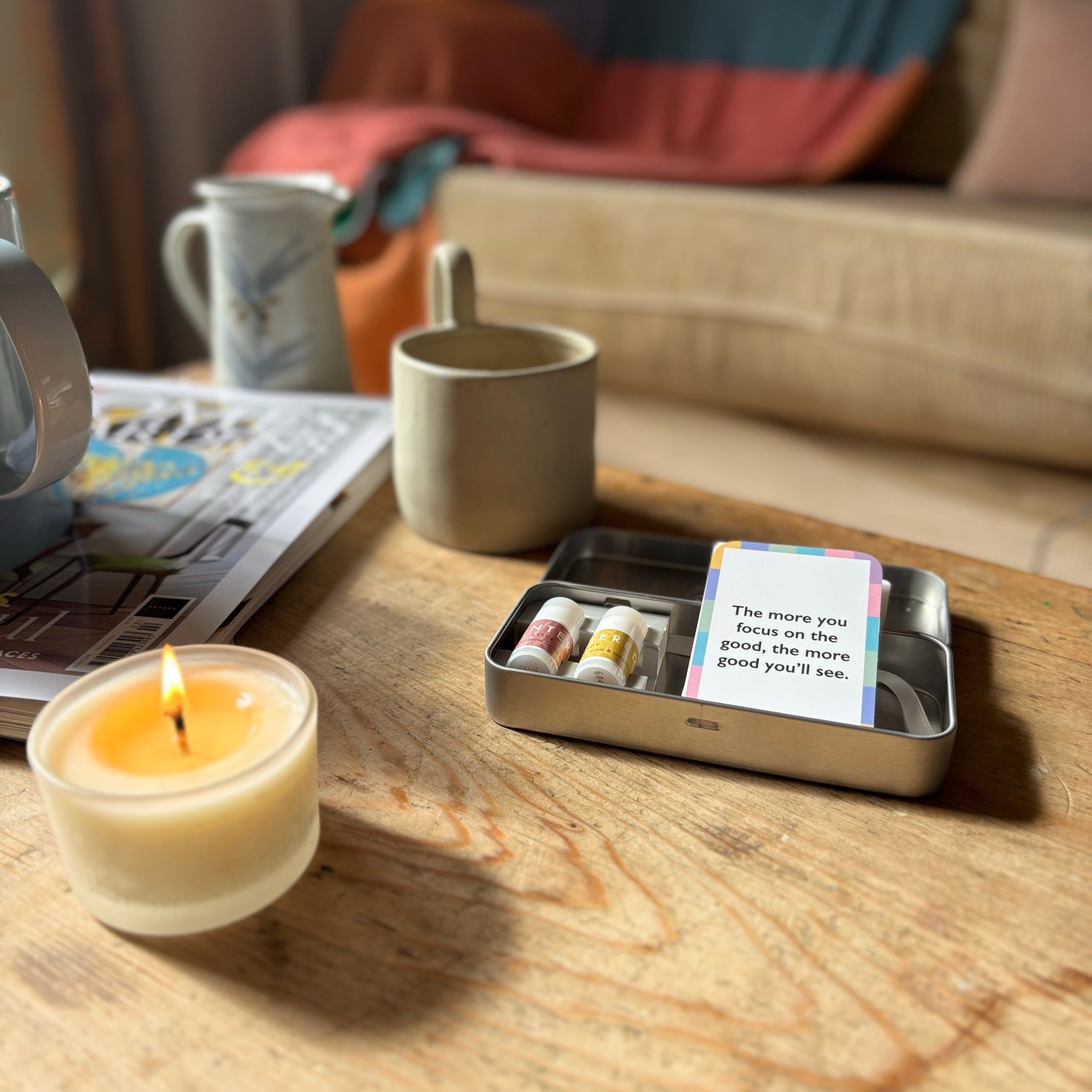 Candle, mug, and happy and love mini balms affirmation set on a desk