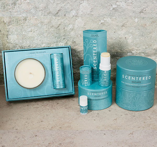 The Scentered product range in the Escape scent which features the Escape home candle, the Escape travel candle, the Escape aromatherapy balm, Escapes mini aromatherapy balm, and Escape balm and candle gift set.
