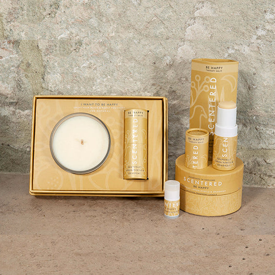 The Scentered product range in the Happy scent which features the Happy travel candle, the Happy aromatherapy balm, Happy mini aromatherapy balm, and Happy balm and candle gift set. Scentered's Happy Aromatherapy Balm, an uplifting citrus-infused balm designed to boost happiness and energy.