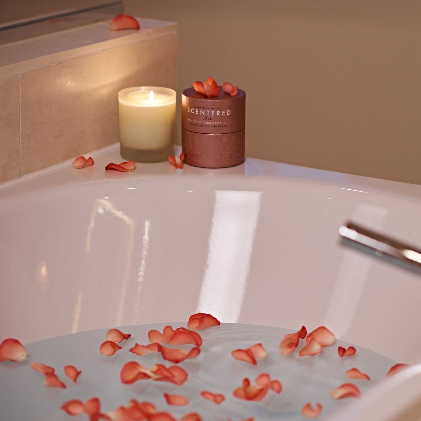 A lit Scentered Love Home Candle next to its packaging near the bath tub with rose petals, love blend candle was created to help you rebalance and reconnect emotionally. For when you want to feel connected with others or times when you need soothing self-care, it’s like a hug you give to yourself.