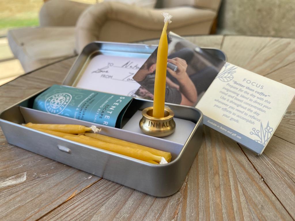 The Scentered Escape mindful relaxation gift set open on a table, featuring the brass candle holder with a 20-minute beeswax meditation candle standing inside