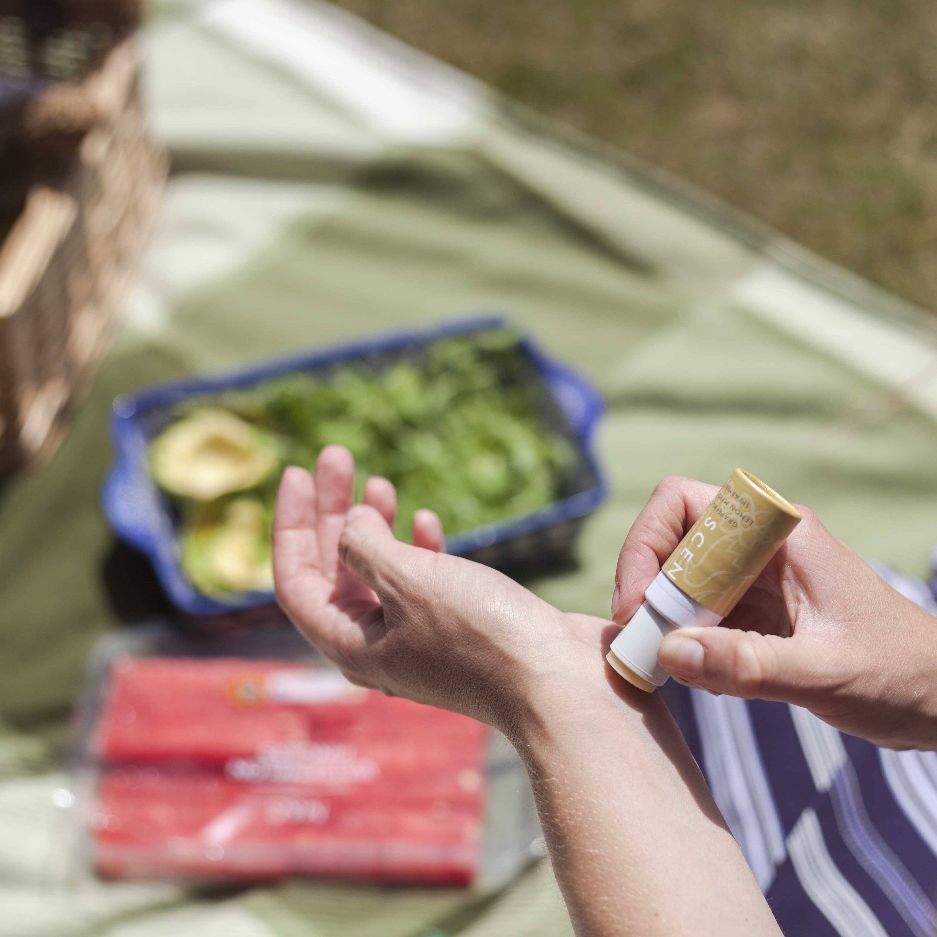 Happy Aromatherapy balm applied to wrist while out in sun on a picnic, find your daily dose of happiness with our Happy Aromatherapy Balm, perfect for a mental pick-me-up.